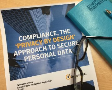 A pair of glasses and notebook on a Symantec Compliance guide GDPR