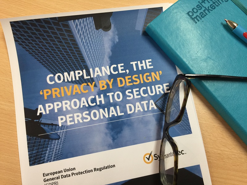 A pair of glasses and notebook on a Symantec Compliance guide GDPR