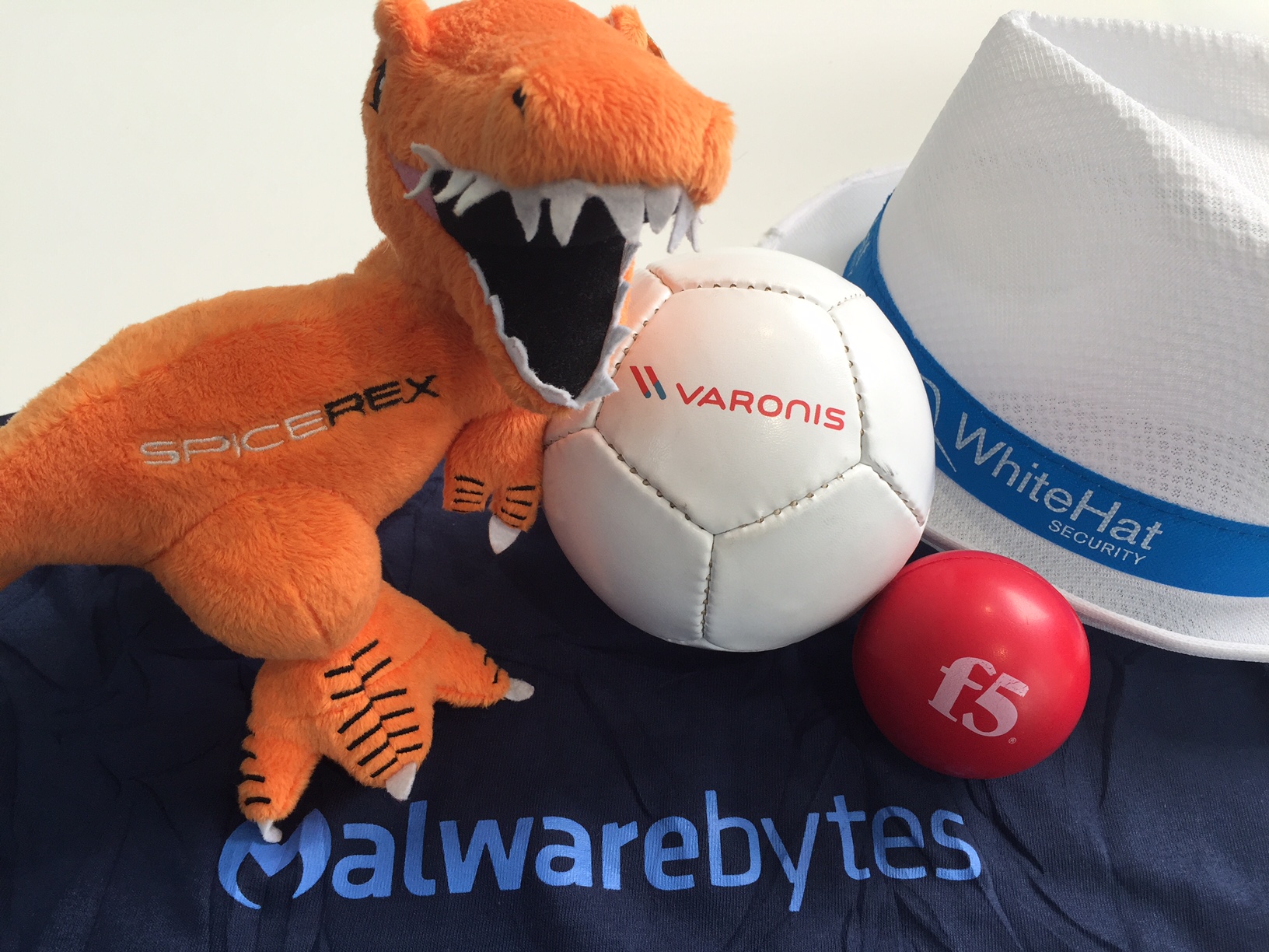 A plush T-Rex next to a ball and a hat - Marketeers