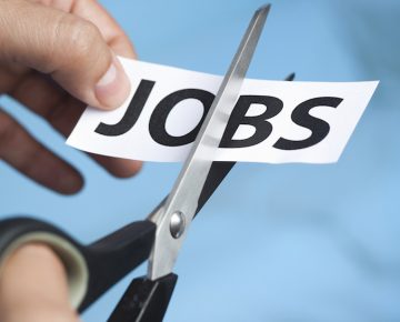 A paper printed with the word "jobs" being cut with scissors