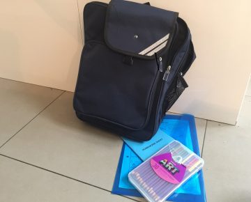 A black school bag and school supplies