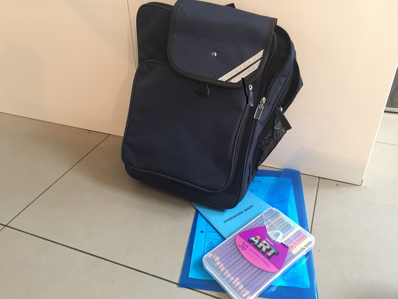A black school bag and school supplies