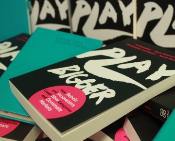 A Play Bigger book and a Positive branded notebook on the Play Bigger stand - Businesses