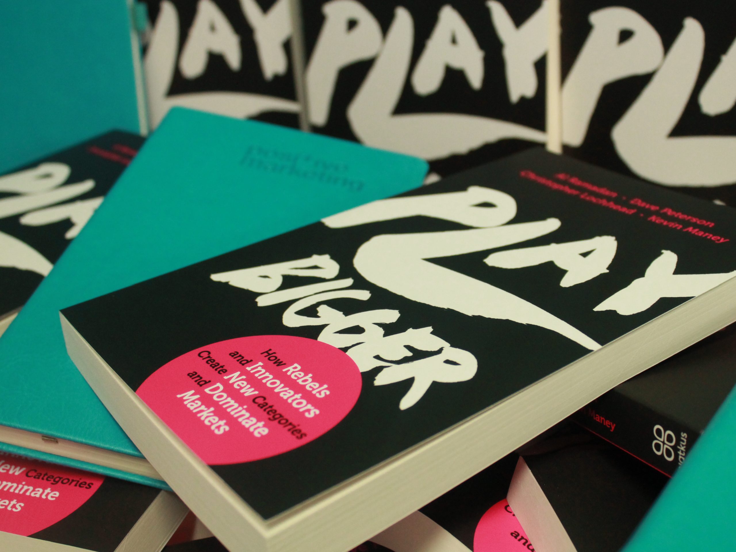 A Play Bigger book and a Positive branded notebook on the Play Bigger stand - Businesses