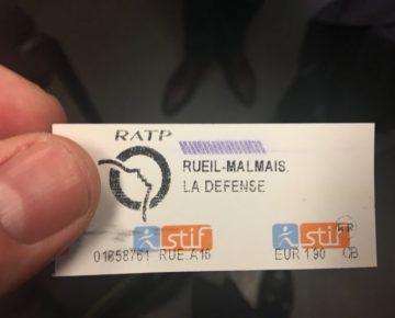 A hand holding a French public transport ticket