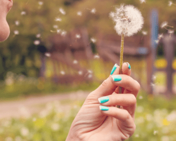 woman blowing dandelion - byline
